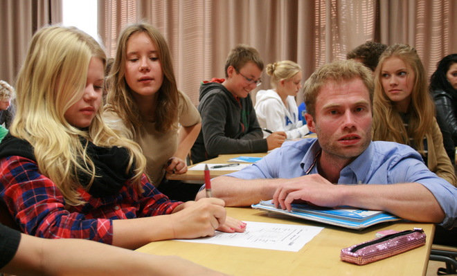 FINLAND - "A pipeline of highly qualified, well-respected teachers in Finland work hard to help all students reach a basic level of achievement by the end of 9th grade." photo by Erin Richards At the Normal Lyceum of Helsinki, English-language teacher Taneli Nordberg helps students with noun-adjective agreement exercises. Nordberg is a product of the selective teacher recruitment and training program at the University of Helsinki.